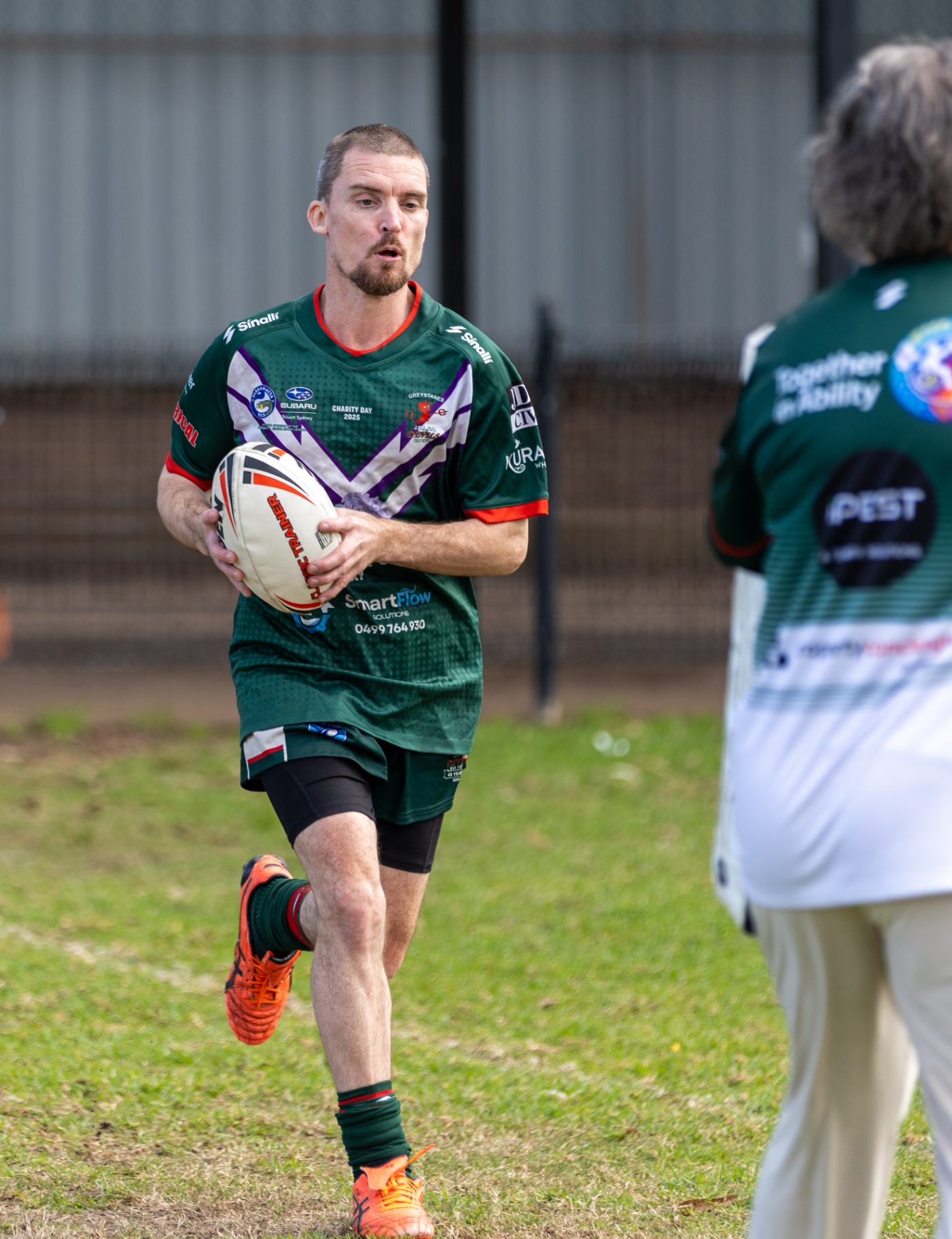 A Together in Ability player running with the football on charity day