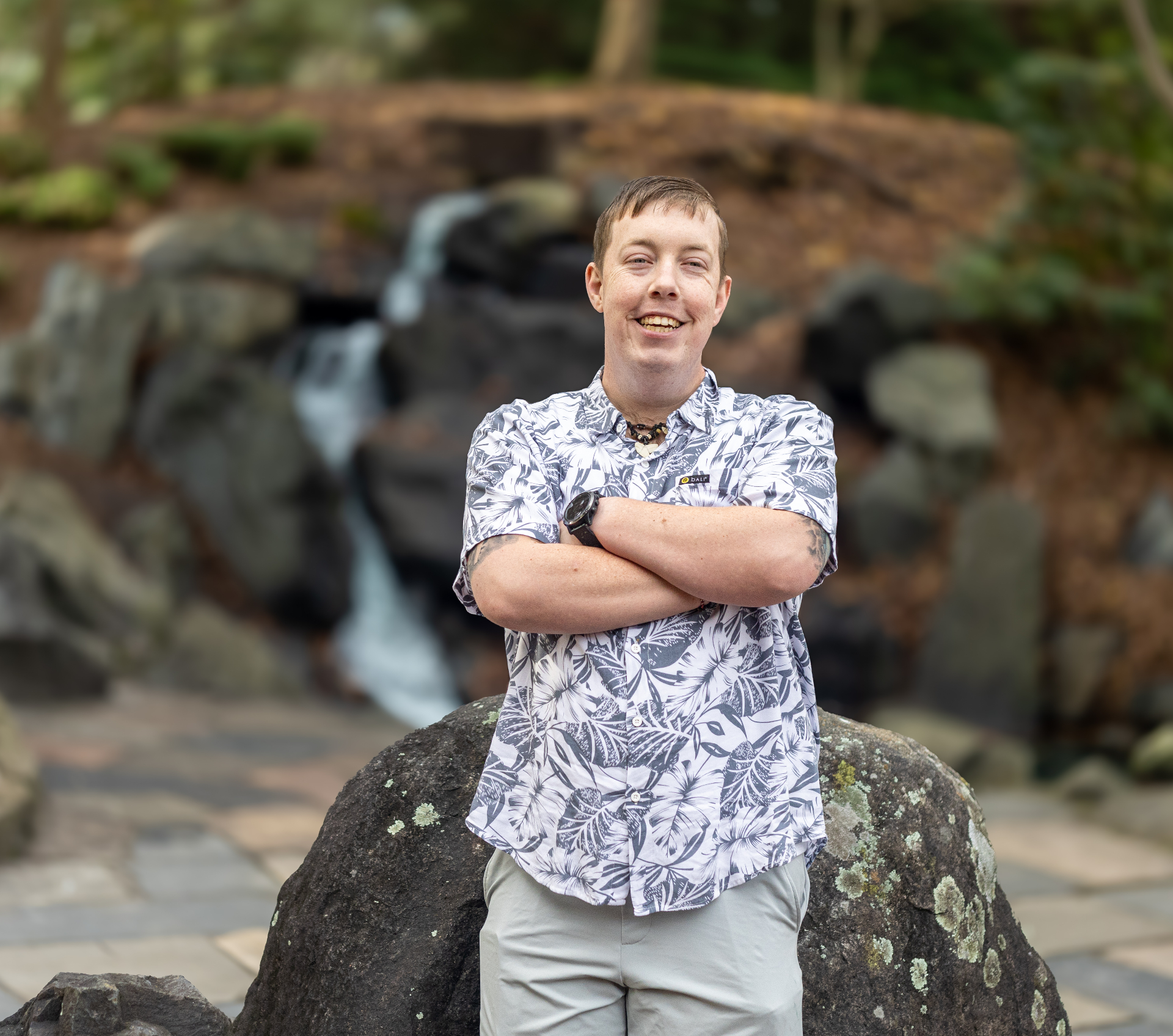 A participant standing proudly in front of a waterfall
