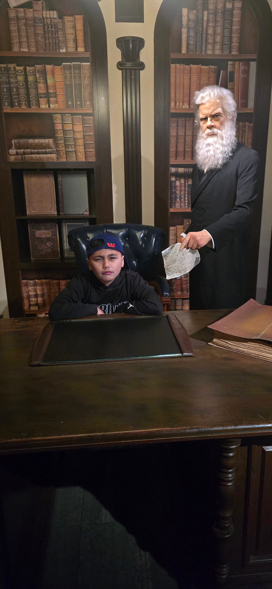A young participant seated at a historic desk display