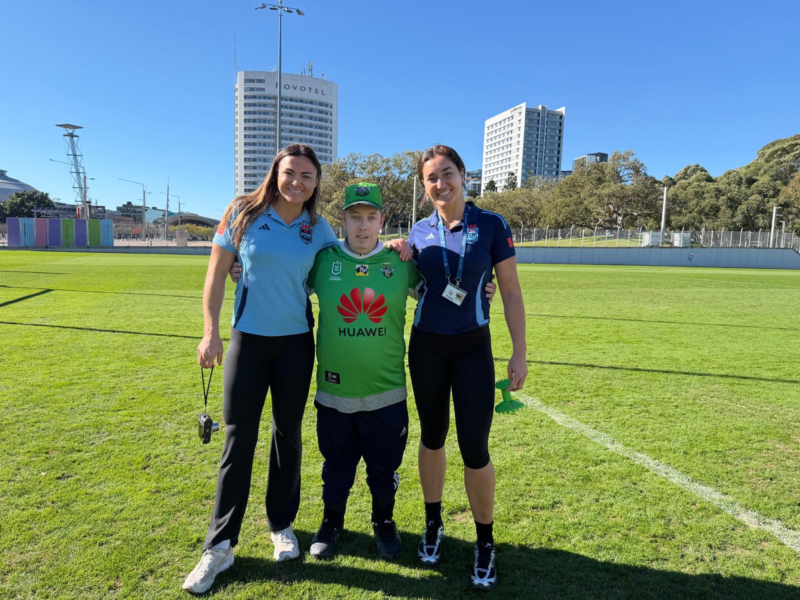 A participant meeting NSW rugby league players on the field