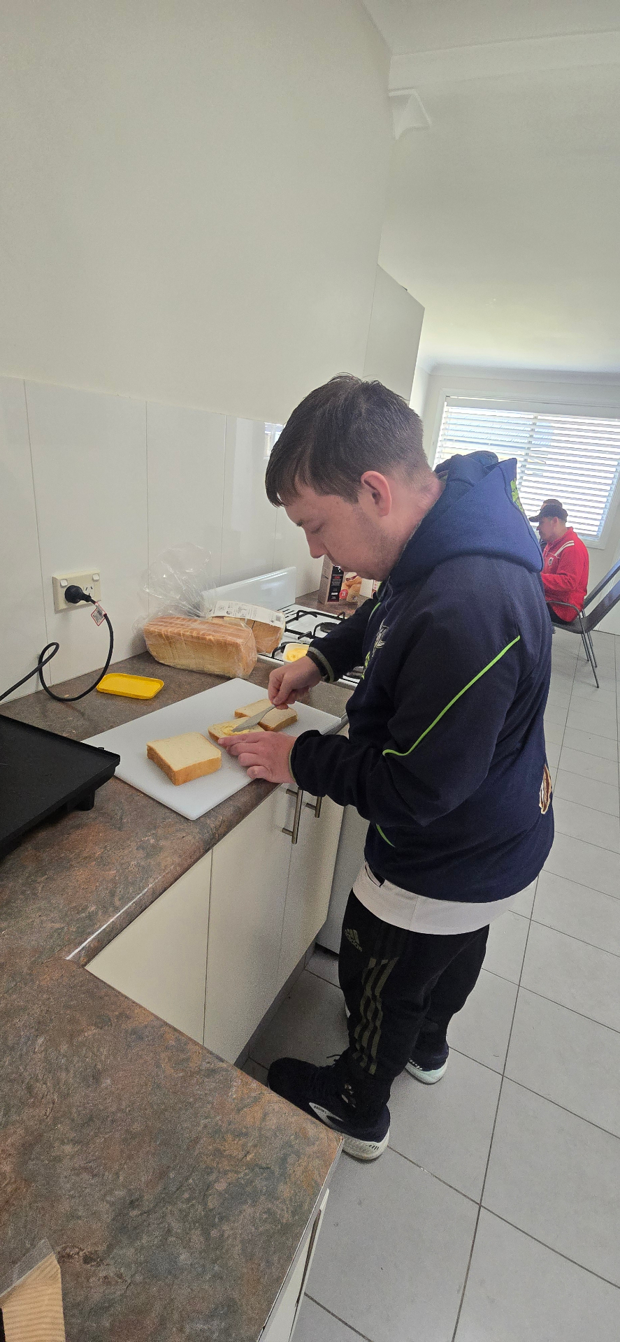 A participant making sandwiches in the kitchen at the hub