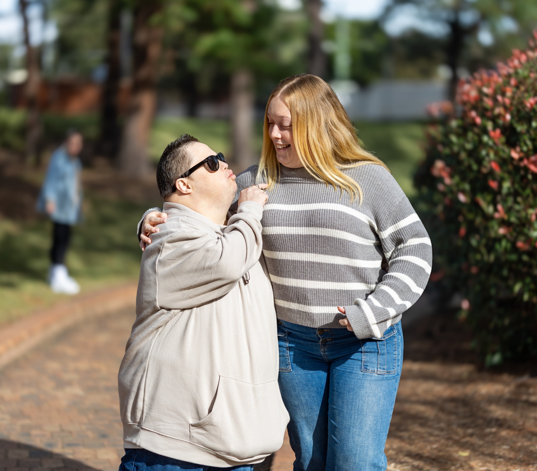 Two friends sharing a laugh together on a garden path