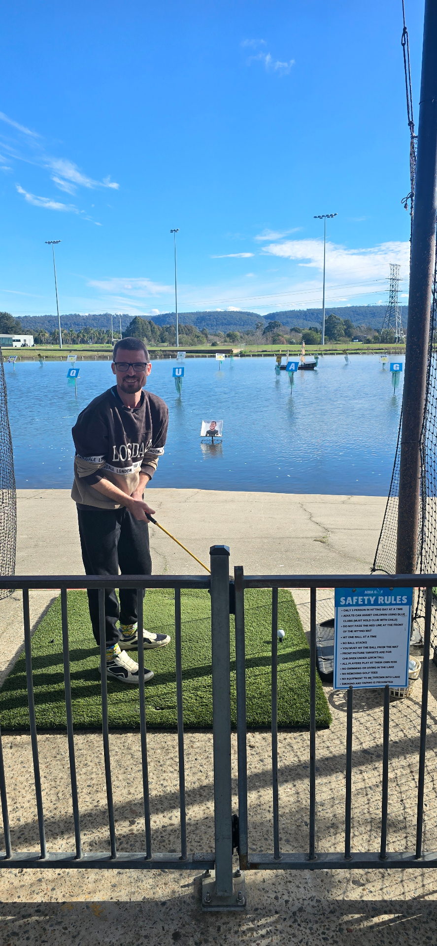 A participant teeing off at the aqua golf driving range