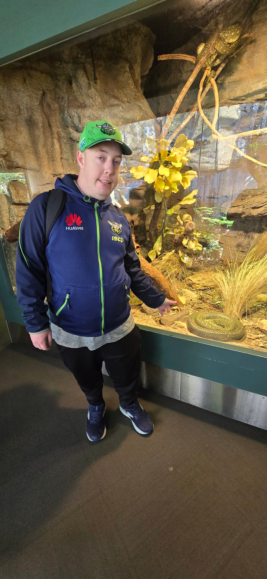 A participant beside a reptile display at a wildlife park